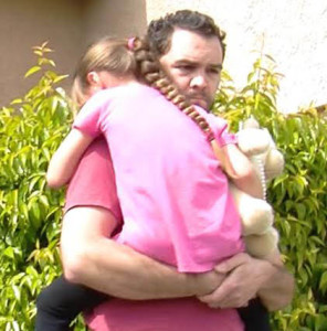 Rusty Page carrying 6-year-old Lexi to the waiting car on Monday.