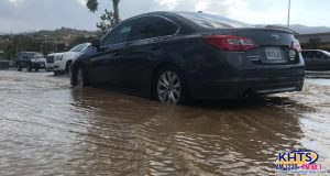 A photo of a car in a flooded parking lot.