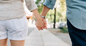 Couple Holding Hands on Sidewalk