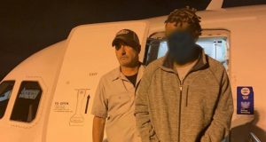Kenneth Mitchell being escorted off an airplane