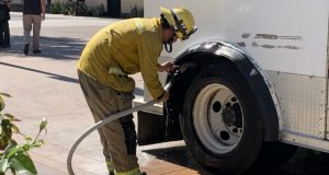 A firefighter putting out a small tire fire.