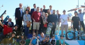 Officials pose by the mural