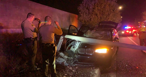 Two deputies survey the SUV under the topple light standard.