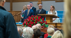 Speakers staged over Condie's casket, seen from the middle of the crowd.