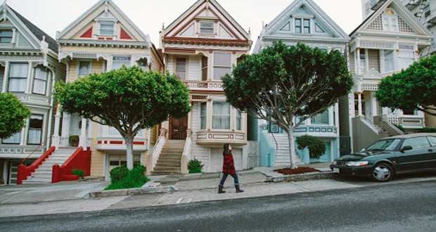 Woman walking in front of row of houses