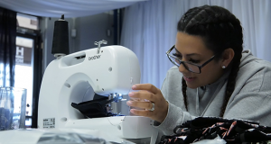 Reyes sewing a mask in her party rental shop.