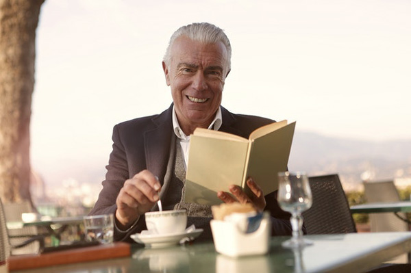 Man reading a book and drinking coffee