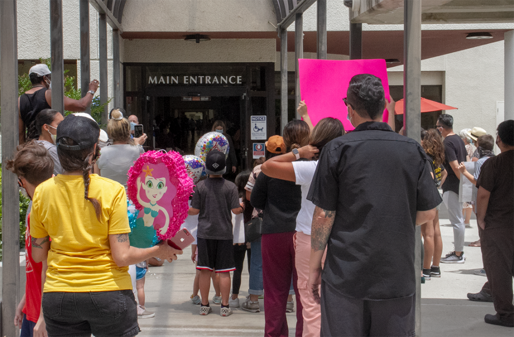 Dozens of friends and family waiting for Miranda Jr. to be wheel out the main entrance to Henry Mayo.