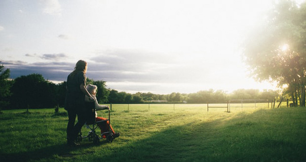 Woman pushing older woman in wheelchair