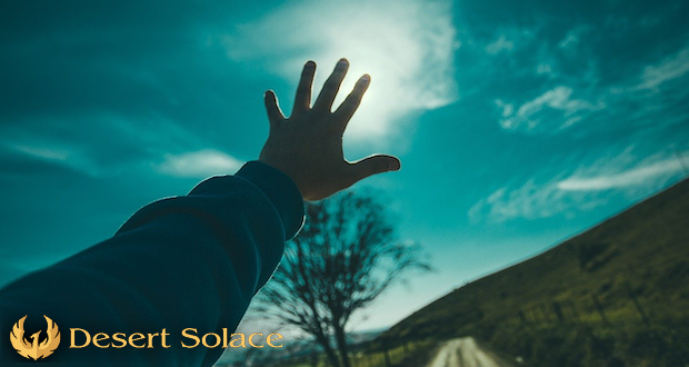 Desert Solace - An arm reaching out for a blue sky
