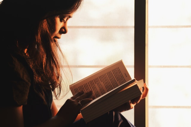 Woman reading in front of window