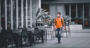 Restaurant with guy in a mask walking