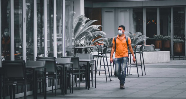 Restaurant with guy in a mask walking