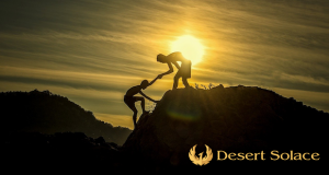 Desert Solace - Inpatient Addiction Treatment Center Explains Importance Of Sponsors - Two silhouettes hiking in the hills, one reaching out to help another reach the summit