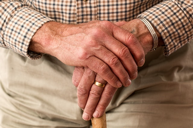 Elderly man holding his hand