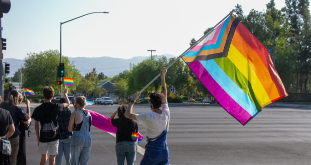 Demonstrator waving a Progress Pride Flag near Bridgeport Park