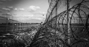 A chain link fence covered in razor wire.