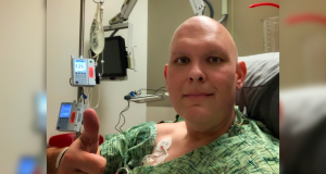 Joshua Dubin holding a thumbs up in a selfie style photo sitting within a treatment facility.