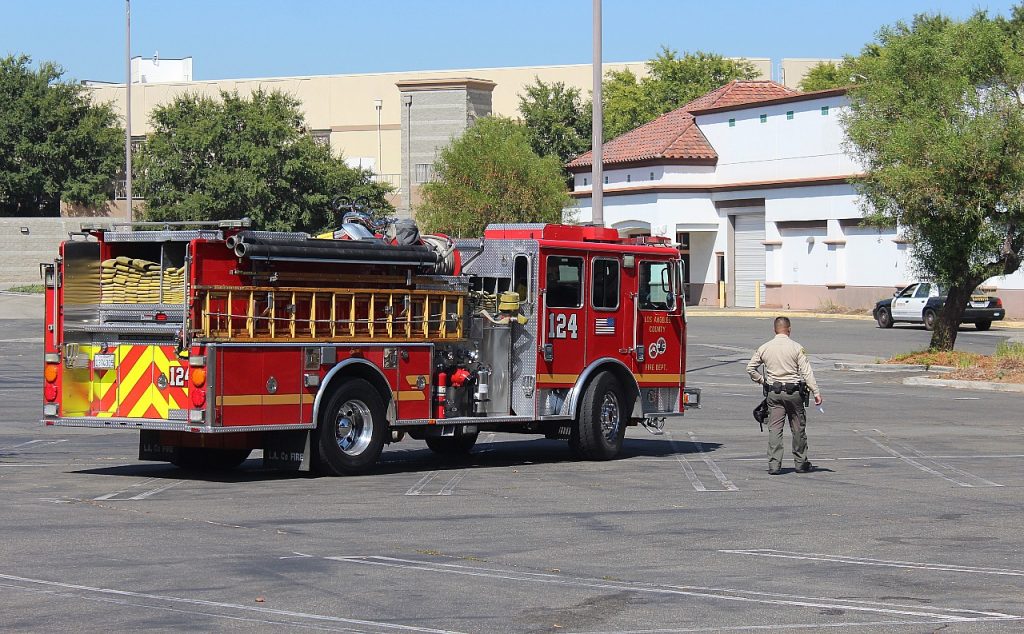 A deputy walks by a fire engine